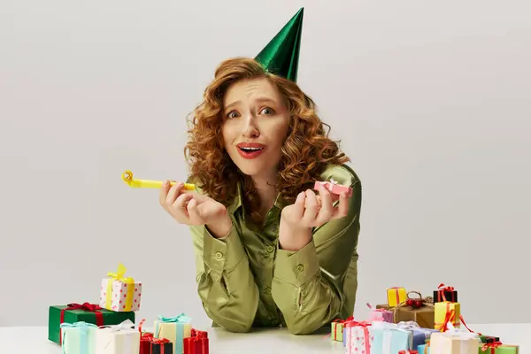 A young woman with curly hair enthusiastically posing cheerfully at a festive party atmosphere. — Stock Photo