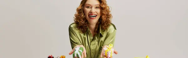 A young woman expresses happiness while posing in vibrant paper and ribbons. — Stock Photo