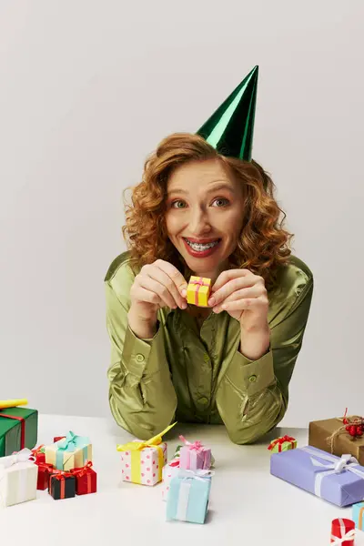 Une jeune femme joyeuse pose avec excitation, entourée de cadeaux colorés. — Photo de stock