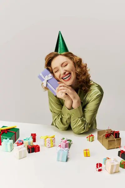 The young woman enjoys posing while surrounded by various presents. — Stock Photo