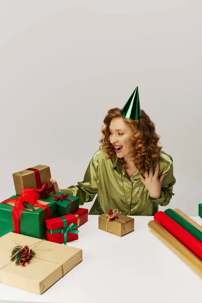 A happy woman posing amid festive decorations and supplies. — Stock Photo