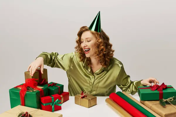 The young woman is happily posing cheerfully with vibrant wrapping paper and ribbons at a lively event. — Stock Photo