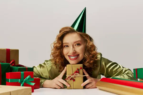 A cheerful young woman posing cheerfully with care, embracing the festive spirit among bright decor. — Stock Photo