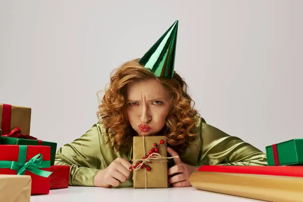 Una giovane donna con i capelli ricci guarda giocosamente frustrato mentre posa allegramente per una celebrazione. — Foto stock