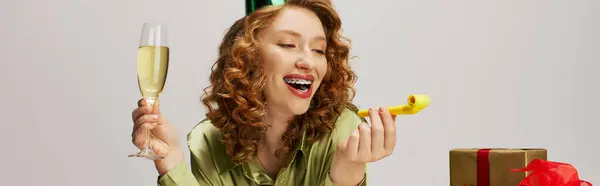 A young woman wrapped in festive cheer holds a drink, savoring the joy. — Stock Photo