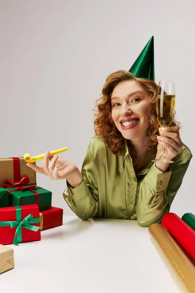 A young woman joyfully posing while holding a drink, embracing the festive spirit. — Stock Photo