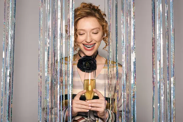 A young woman smiles brightly as she posing cheerfully, radiating joy amidst festive decorations. — Stock Photo