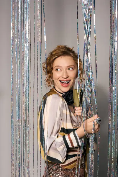The cheerful young woman posing cheerfully surrounded by sparkling decorations. — Stock Photo