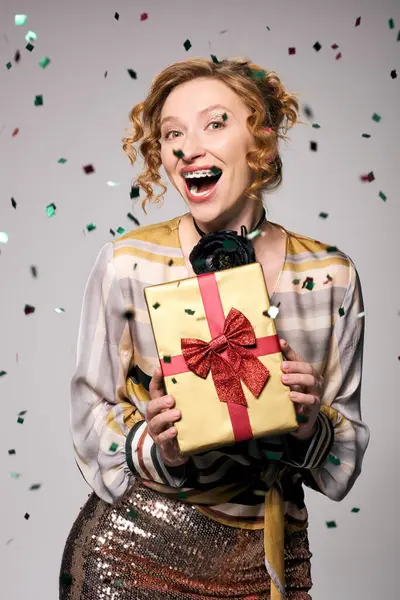 A cheerful young woman passionately posing while enjoying the celebratory mood. — Stock Photo