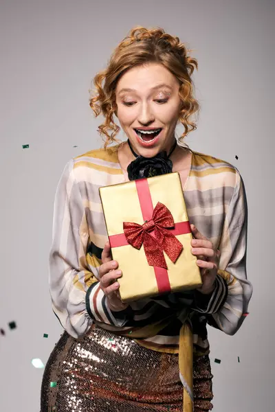 A joyful young woman posing with a bright red bow, celebrating the moment. — Stock Photo