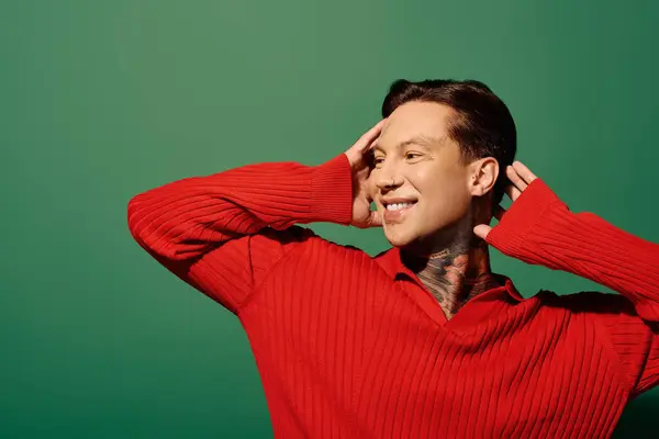 A young man with tattoos smiles widely while posing playfully in a bright setting. — Stock Photo