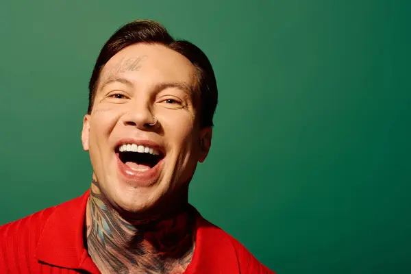 A young man with an engaging smile showcases his colorful tattoos while posing brightly. — Stock Photo