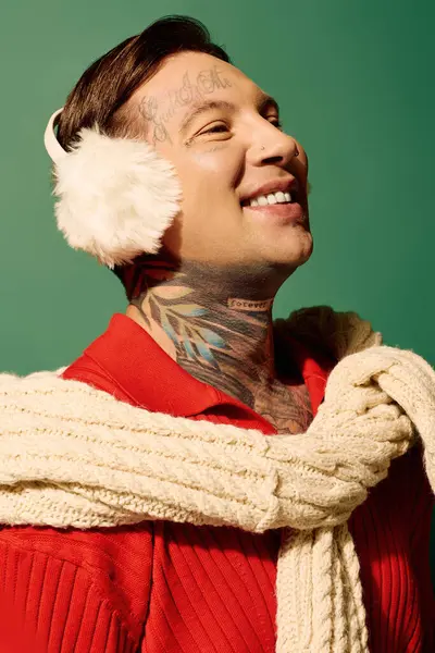 A smiling young man with elaborate tattoos showcases his playful winter fashion accessories. — Stock Photo