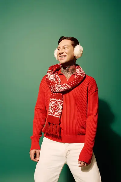 A happy young man in winter wear smiles, showing off his tattoos against a bright backdrop. — Stock Photo