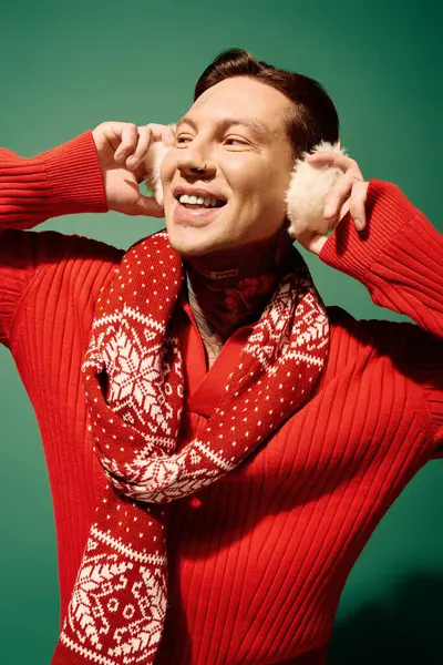 A cheerful young man with tattoos embraces the winter spirit, smiling and dressed warmly. — Stock Photo