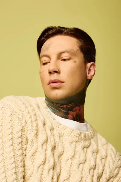 A young man adorned with intricate tattoos showcases a contemplative expression in a warm setting. — Stock Photo