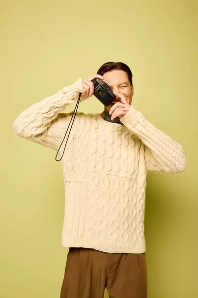 A young man with tattoos joyfully holds a camera, ready to capture the essence around him. — Stock Photo
