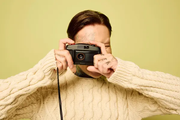 Um jovem, adornado com tatuagens, se dedica à fotografia com uma expressão alegre. — Fotografia de Stock