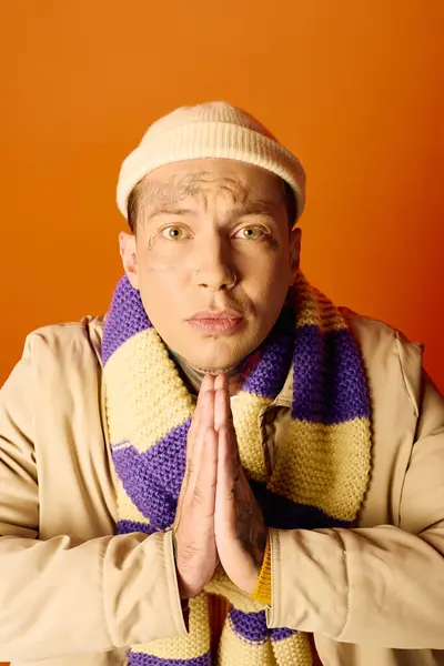 A young man with intricate tattoos expresses gratitude while dressed warmly and stylishly. — Stock Photo