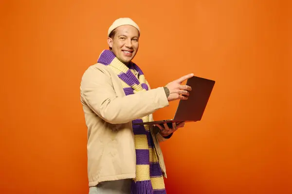 The young man with tattoos enthusiastically interacts with his laptop, smiling brightly. — Stock Photo