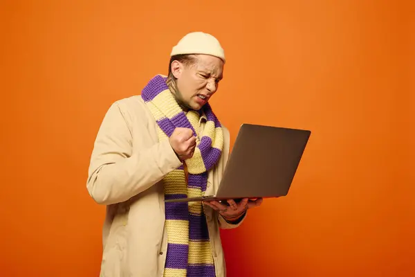 A young man with tattoos joyfully expresses his excitement while using a laptop. — Stock Photo