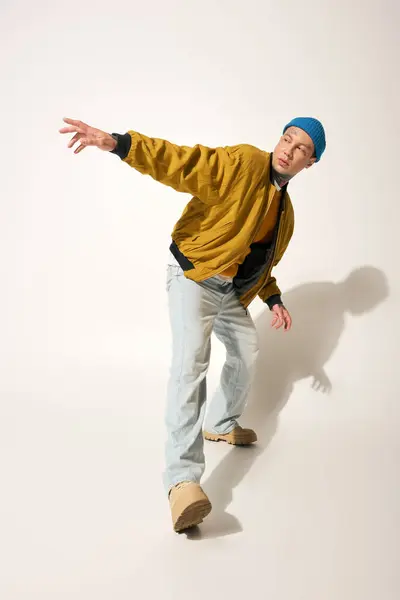A young man in a vibrant outfit showcases his unique style with tattoos in a modern setting. — Stock Photo