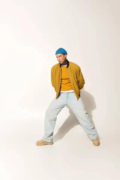 A young man with tattoos stands stylishly, expressing confidence in a creative outfit. — Stock Photo