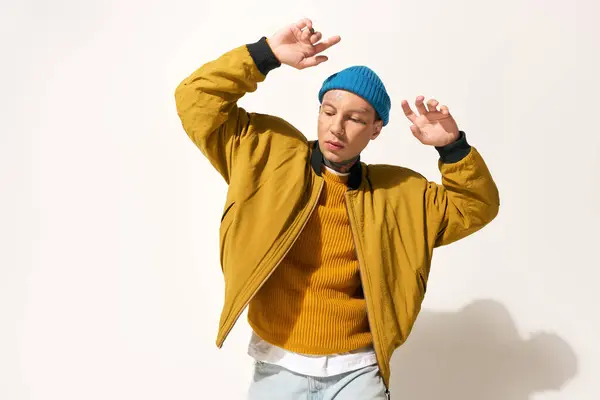 The young man showcases his tattoos while dancing with enthusiasm in a trendy outfit. — Stock Photo