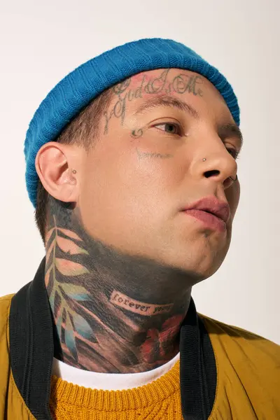 A young man with intricate tattoos expresses his individuality with a vibrant look and attitude. — Stock Photo