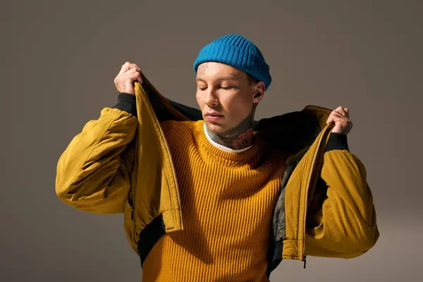 A young man in a bright hat and jacket expresses his individuality through fashion and tattoos. — Stock Photo