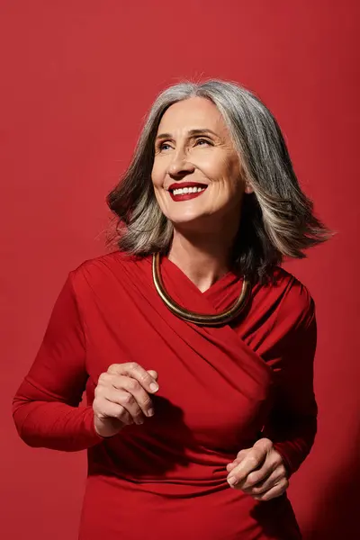 Uma bela mulher madura com cabelos grisalhos celebra alegremente o Natal e o Ano Novo com um sorriso quente.. — Fotografia de Stock