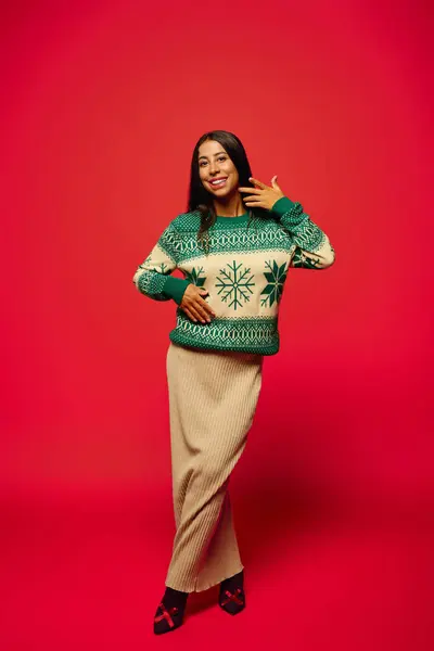 A young woman smiles and poses cheerfully, radiating holiday spirit in a cozy setting. — Stock Photo