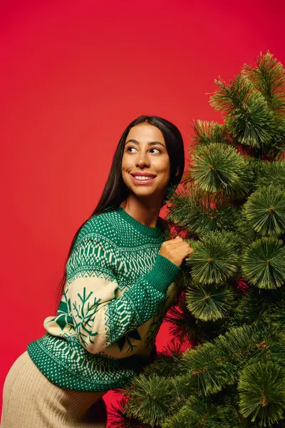 The cheerful woman embraces a lush Christmas tree, radiating holiday spirit and joy. — Stock Photo