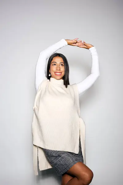 A stylish young woman with a radiant smile poses confidently against a light backdrop. — Stock Photo