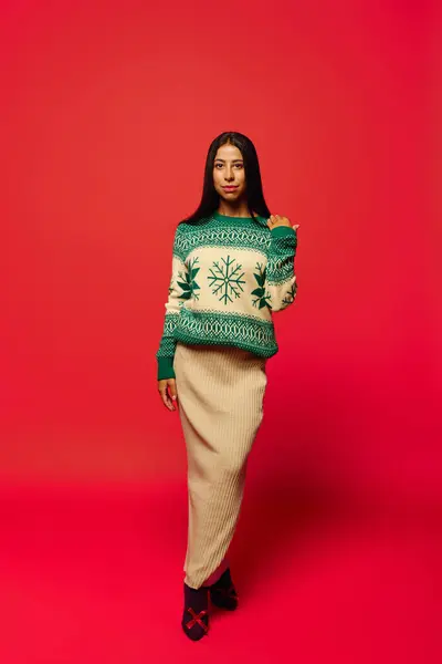 Standing tall, a young woman showcases her unique sweater and stylish skirt with grace. — Stock Photo