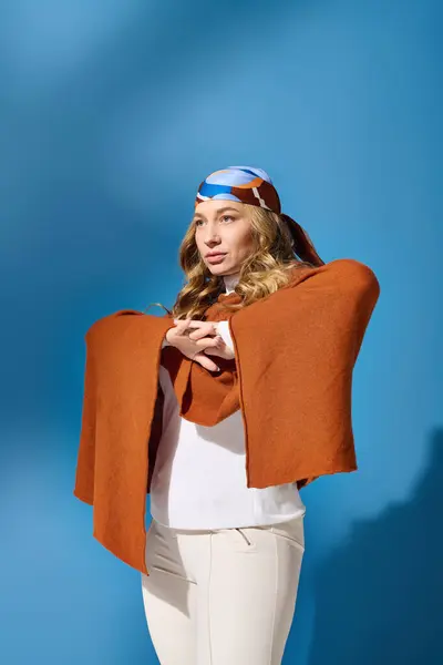 A confident young woman stands gracefully, showcasing her unique style with an eye catching scarf. — Stock Photo