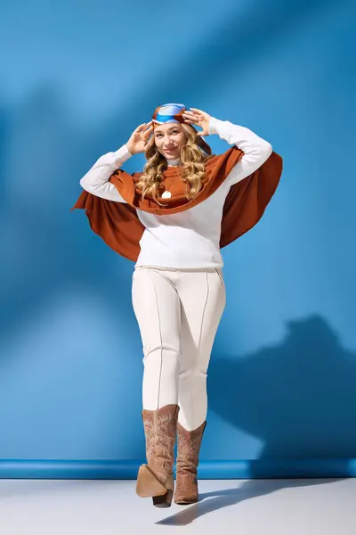 Una joven mujer de moda de talla grande muestra su atuendo de invierno mientras posa juguetonamente en el interior. - foto de stock