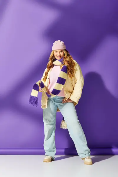 A confident young woman flaunts her style in a vibrant winter outfit with fun accessories. — Stock Photo