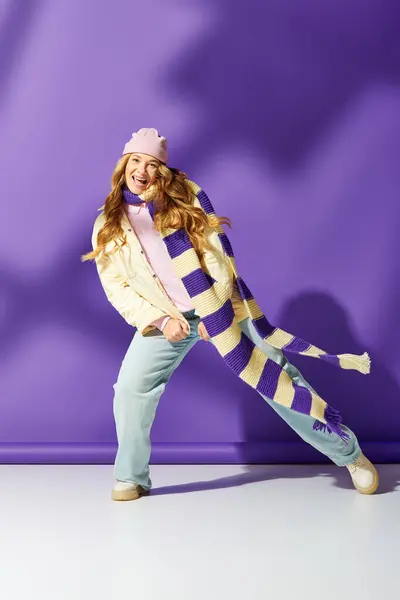 A cheerful plus size woman expresses joy wearing a cozy outfit and colorful scarf. — Stock Photo