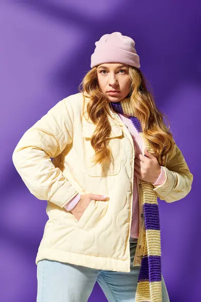 A young beautiful plus size woman poses against a purple background wearing cozy winter clothes. — Stock Photo