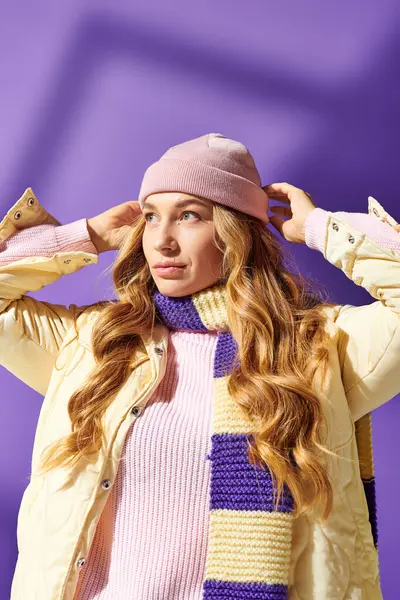 A plus size woman with wavy hair smiles, adjusting her colorful scarf against a purple backdrop. — Stock Photo