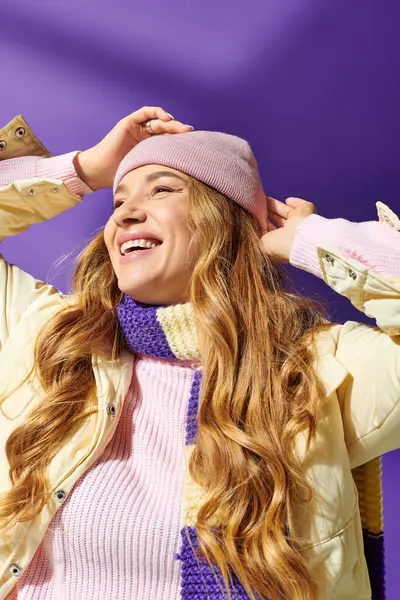A joyful plus size woman smiles in colorful layers against a purple background. — Stock Photo