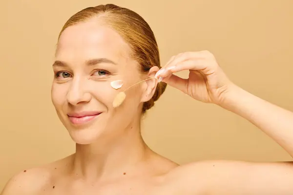 A young beautiful plus size woman gently applies product to her cheek with a joyful expression. — Foto stock