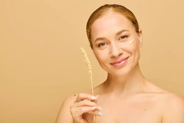 A joyful young woman with radiant skin holds a wheat stalk, embodying beauty and nature. — Stock Photo