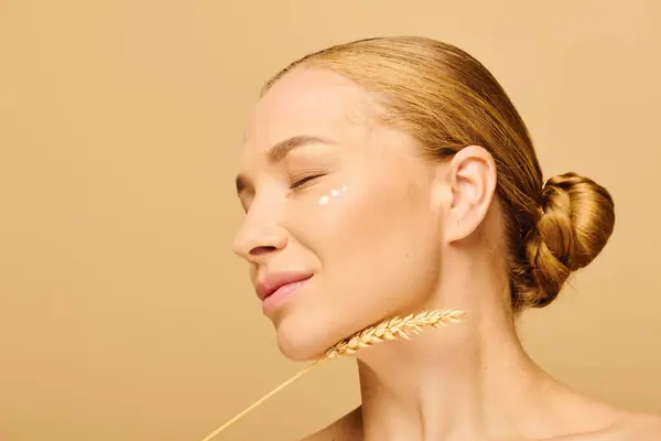 La encantadora mujer de talla grande sonríe suavemente mientras sostiene suavemente un tallo de trigo cerca de su barbilla. — Stock Photo