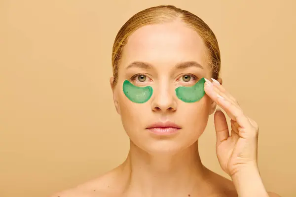 A young beautiful plus size woman applies green eye patches while relaxing in her cozy space. — Stock Photo