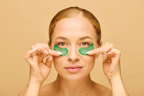 The stunning young woman enhances her beauty routine with vibrant green eye masks for rejuvenation. — Stock Photo