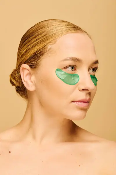 A young plus size woman relaxes with green patches under her eyes during a beauty treatment. — Stockfoto