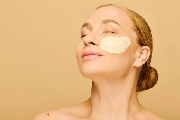A beautiful plus size woman enjoys self care as she applies a hydrating face mask. — Stock Photo