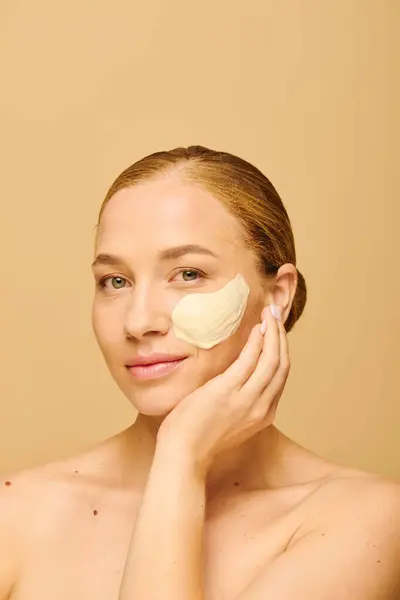 A young beautiful plus size woman gently applies a facial mask, enjoying her self care moment. — Stock Photo